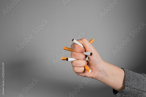 Conceptual image of quitting smoking by crushing a cigarette in a clenched fist, symbolizing strength, determination, breaking addiction, and commitment to a smoke-free lifestyle.