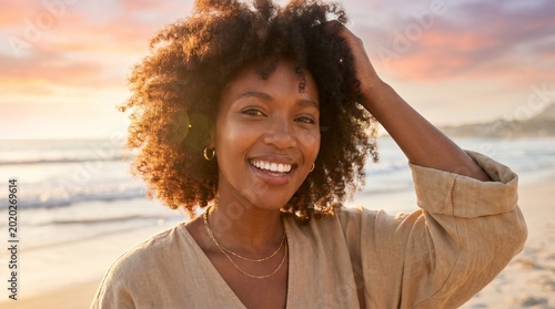 Smiling woman enjoying sunset on the beach