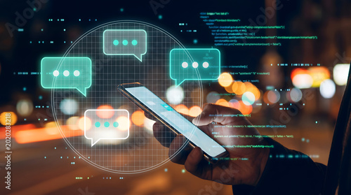 Mobile phone, chat bubbles, nighttime cityscape, digital communication, messaging apps