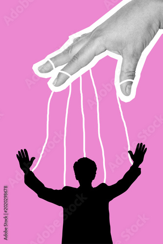 Photos Human figure controlled by strings from a giant hand against a pink background,