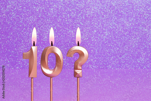 Number 10 and question mark on a pink background with blurred bright dots - Birthday or anniversary card with abstract blurred dots that glow
