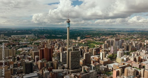 Epic establishing shot of Johannesburg , South Africa. Hillbrow Tower and the vast city skyline. Dramatic aerial urban landscape, dense architecture, and metropolitan horizon. 4K drone zoom out video