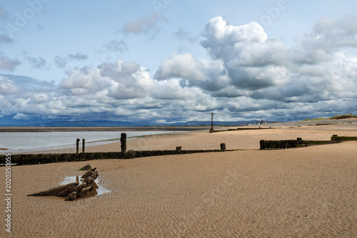 Remains of an old wooden boat buried in the sand on the beach at Fleetwood in Lancashire