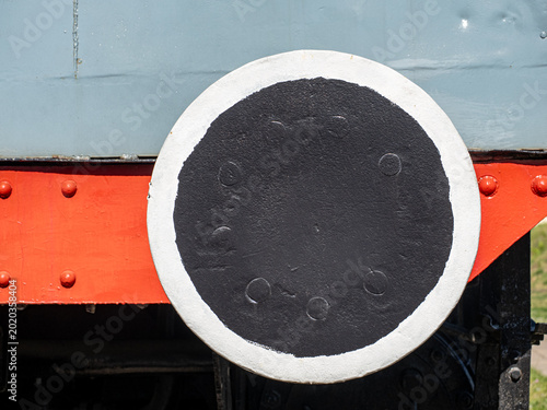 Close-Up Of Locomotive Buffer Plate Painted Black With White Rim On Red Train Front