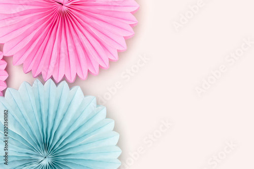 Tissue paper fans in a blue and pink colors on a gray background. Creative composition with copy space.