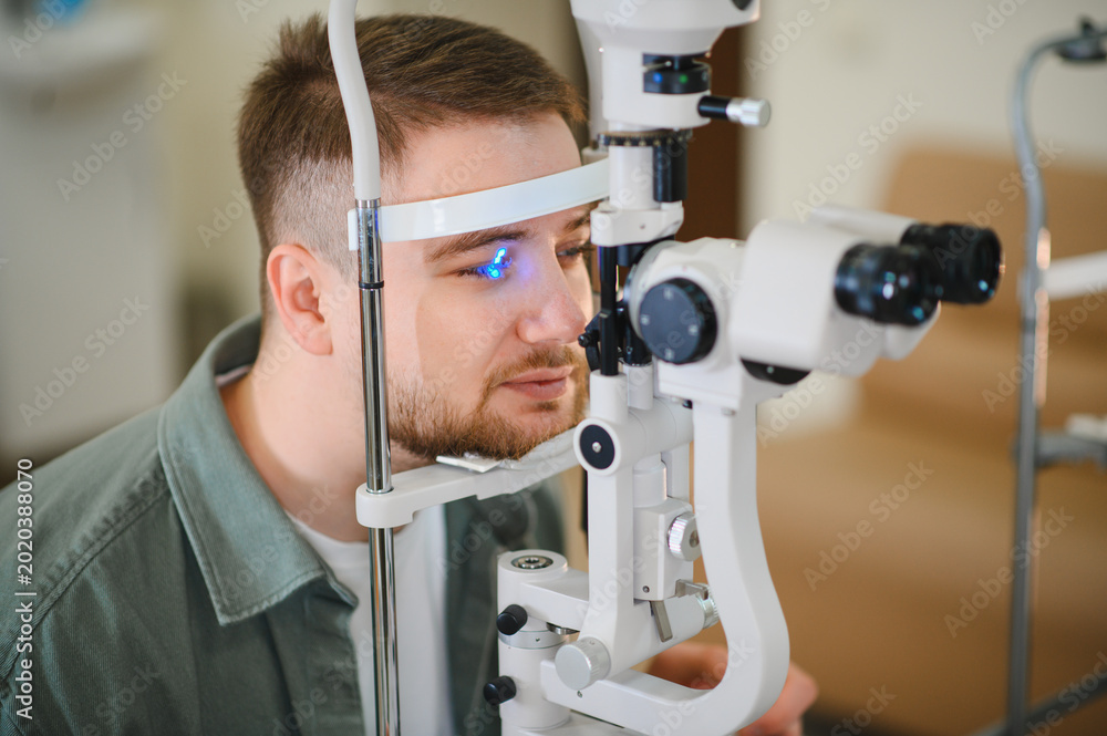 Fotografie Man receiving eye exam with a slit lamp