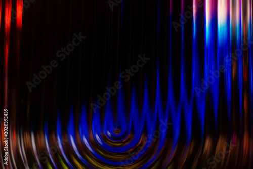 Dark abstract background with bright blue glowing concentric ripples at the base