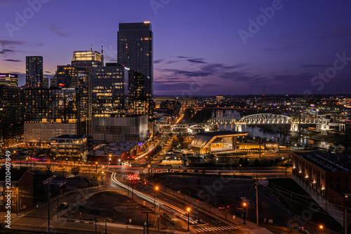Vibrant Cityscape of Nashville at Dusk with Illuminated Skyline and Bridge