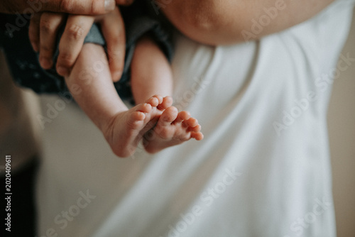 Fotografie Petits pieds de nouveau-né dans les mains de ses parents