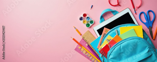 Blue backpack filled with colorful school supplies. Includes notebooks  pencils  watercolors  tablet  and scissors on a pink background. Ready for learning and creative projects.
