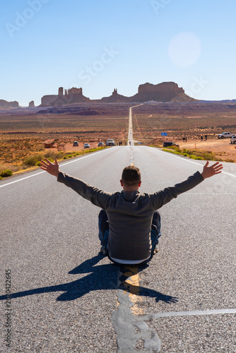 Billede på lærred Man raising arms on u.S. Highway leading to monument valley