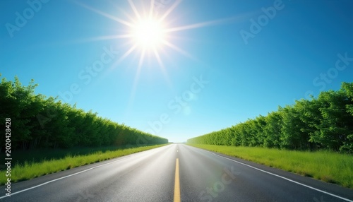 Straight asphalt road with green hedges and bright sun under clear blue sky. Endless path leads to horizon, inviting travel and adventure. Open landscape offers sense of freedom and peace.