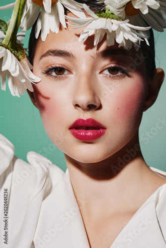 Принти на полотні Close-up of a young woman with vivid pink lipstick and delicate flowers in her hair