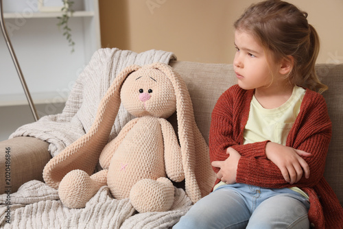 Sad little girl with toy bu...