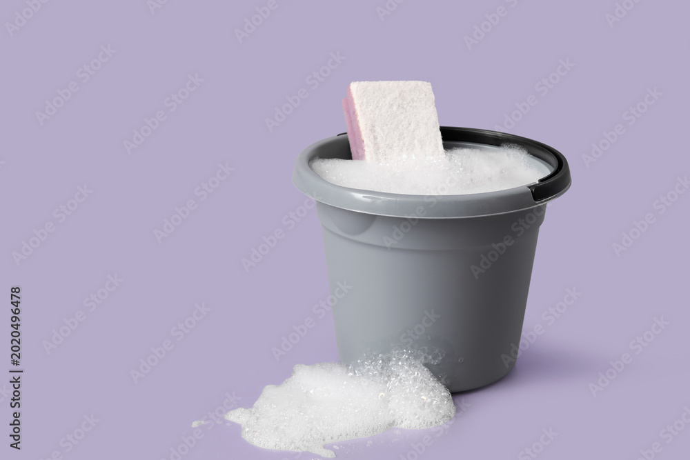 Αυτοκόλλητο Plastic bucket of foam with sponge on purple background