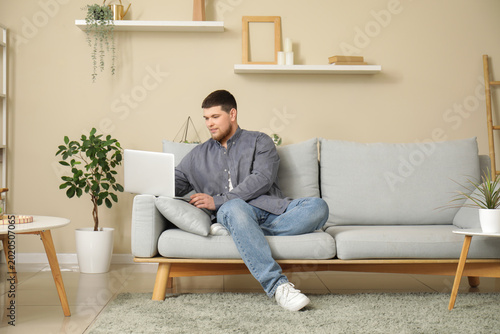 Young man sitting on sofa a...