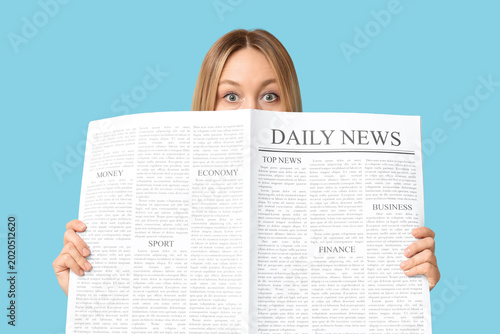 Fotografía Shocked adult woman with newspaper on blue background