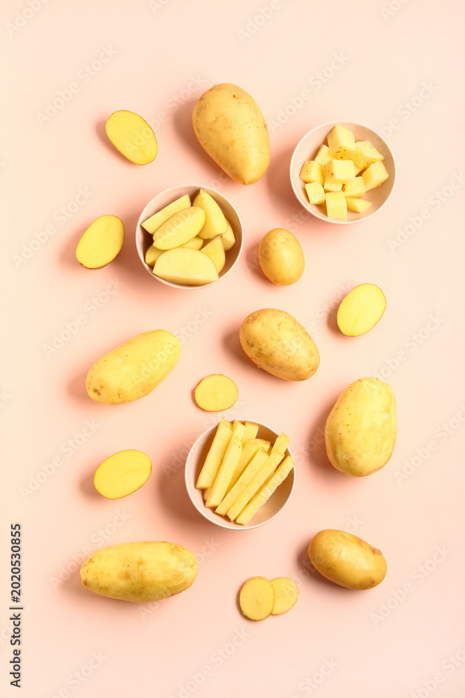 Obraz premium Bowls with cut and whole potatoes on pink background