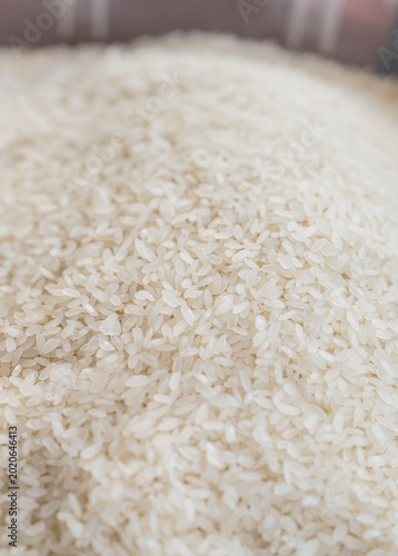 Close-up of uncooked white rice grains forming a natural food texture background