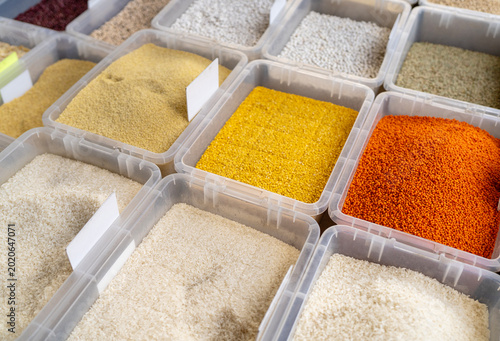 Colorful Grains and Legumes Displayed in Market Containers