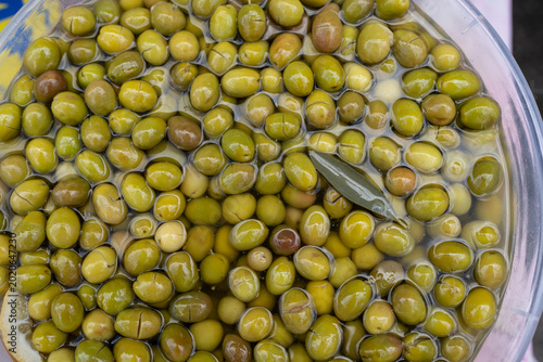 Close-up of green olives soaking in brine, highlighting Mediterranean food culture