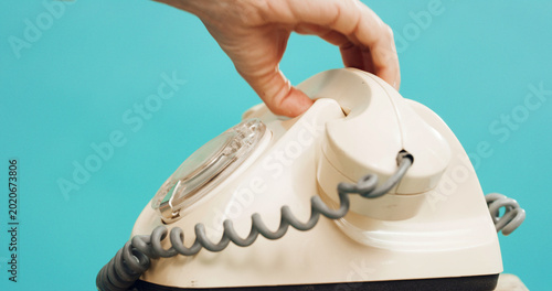 Tablou pe pânză Person, hand and retro dial with telephone in studio for phone call on a blue background