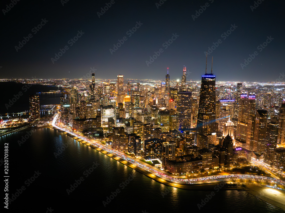 Obraz premium Aerial Night View of Chicago Skyline with Lake Shore Drive Illuminated Traffic and Lake Michigan Shoreline