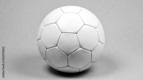 Soccer ball all white standing on gray studio background