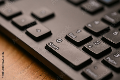 Obraz na plátně Side Angled Top View Macro Close-Up Black Keyboard Highlighting Zero and Insert