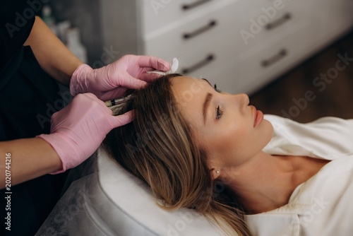 Woman getting mesotherapy injection for hair growth on scalp