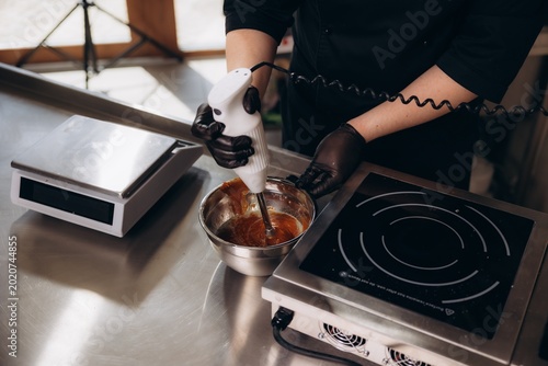 Photos Chef blending caramel with immersion blender in kitchen