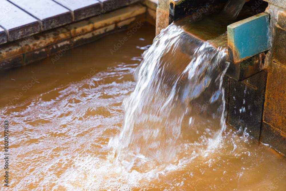 Ταπετσαρία Hot onsen water flowing from a wooden pipe into a bath