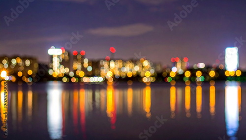 Blurred Cityscape Lights Reflecting on Lake Water at Night