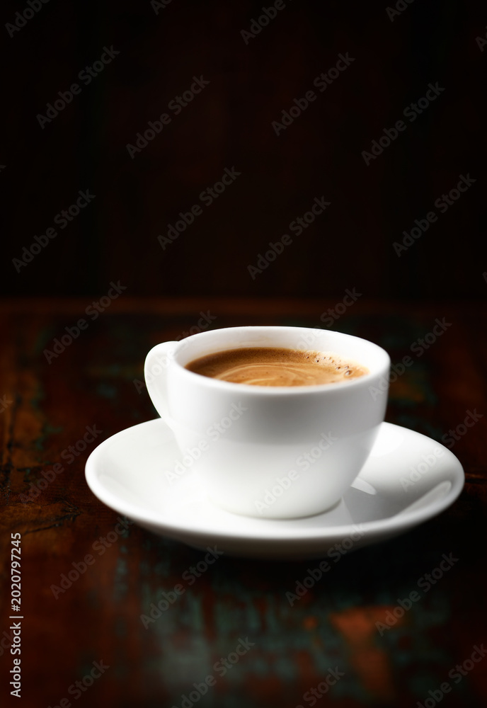 Fototapeta premium Cup of coffee on rustic wooden background. Soft focus. Copy space