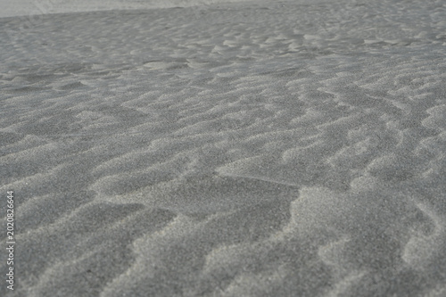 Monochrome Abstract Texture of Wind-Swept Volcanic Black Sand Ripples on a Beach