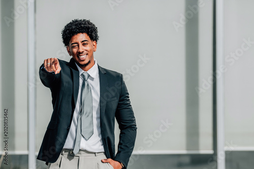 Foto smiling businessman pointing with copyspace