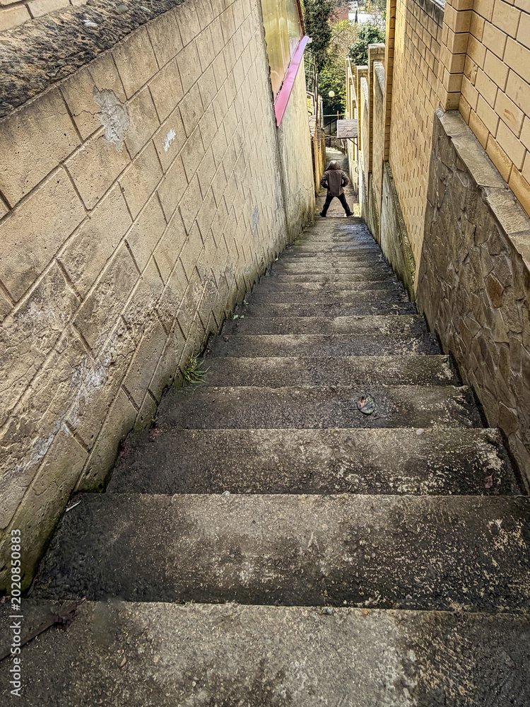 Fototapeta premium Man stands at top of steep concrete stairs