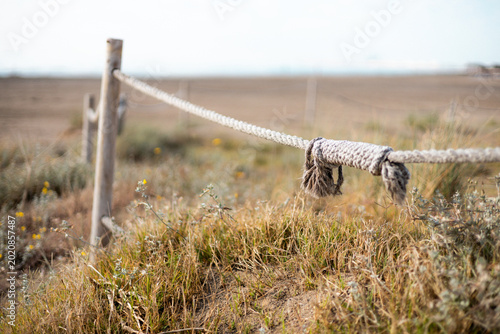 A beach on a cloudy day with a pole and a rope