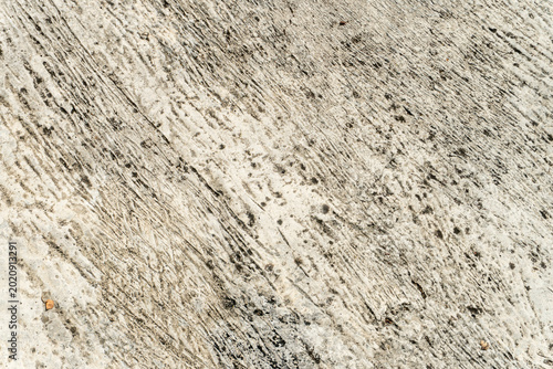 Foto Textured concrete surfaces, characterized by a mottled, light-colored appearance with dark spots, streaks, and pits