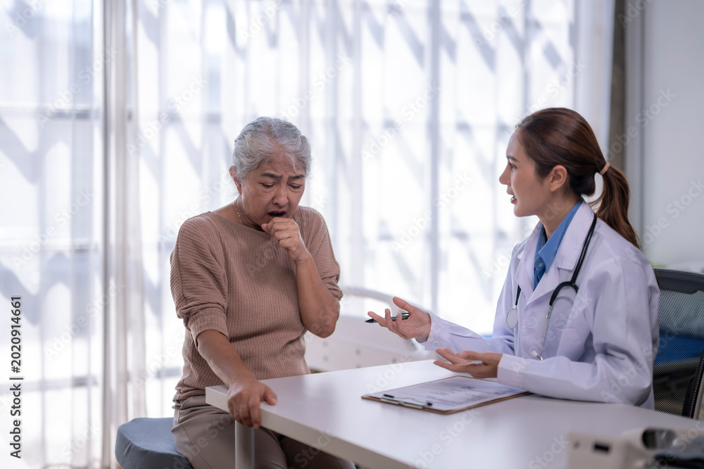 Obraz premium Elderly woman coughing during medical consultation with doctor