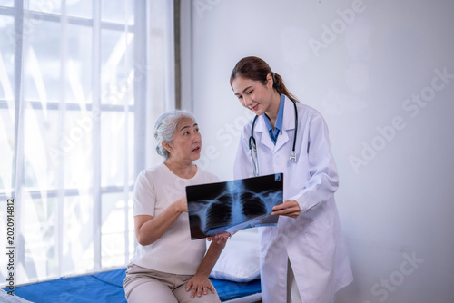 Bilde på lerret Doctor discussing x-ray with senior patient in hospital