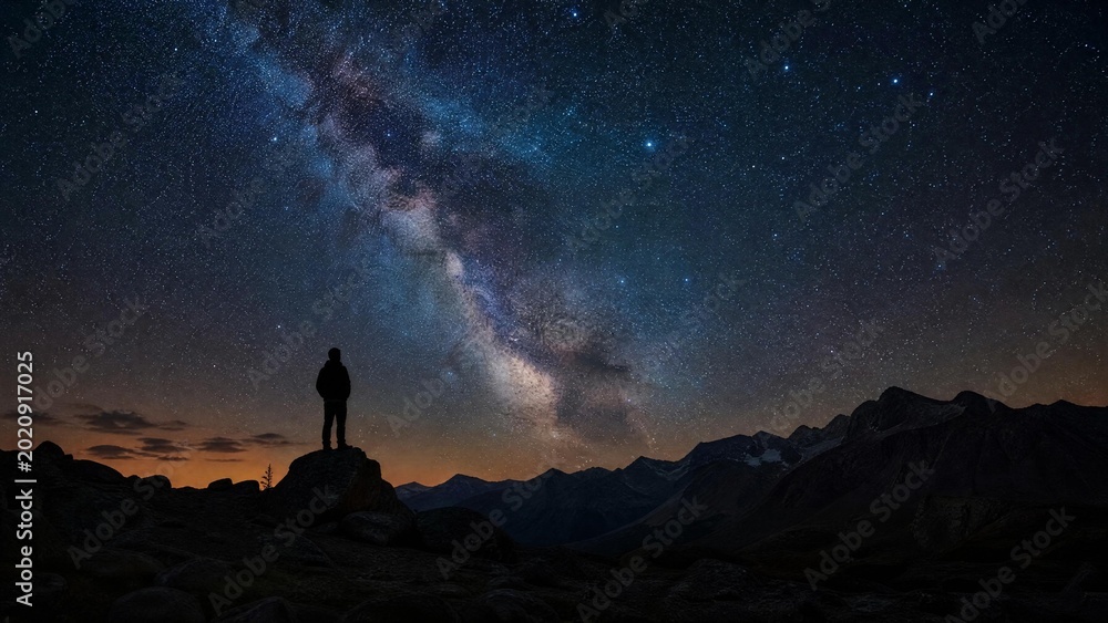Fototapeta premium Man Silhouette Stargazing Under the Milky Way Galaxy on Mountain Peak