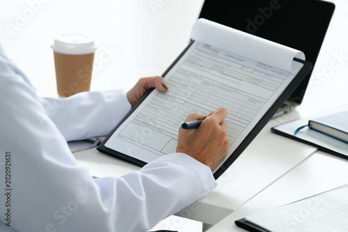 Medical doctor checks patient reports and notes in clinic