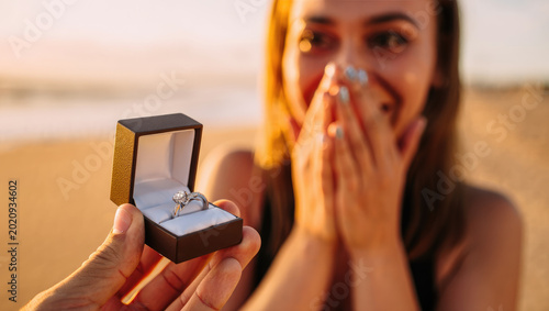 Diamond engagement ring proposal at sunset beach, romantic surprise, emotional reaction, celebration, love, social media content, wedding planning