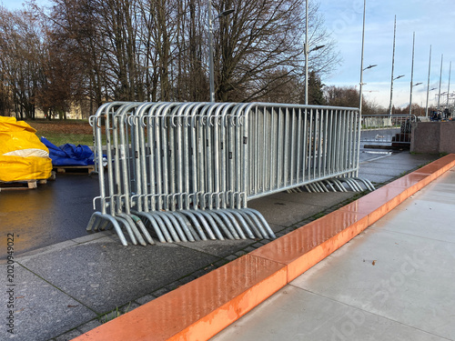 Control barriers on the street. Steel pedestrian barricades lined up. Metal portable fencing for event security and temporary border management.