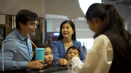 Family is go to watch movie at cinema complex during weekend. Lifestyle, weekend activity.