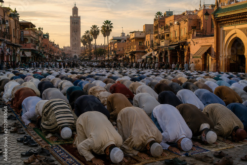 Muslim worshippers praying in traditional Moroccan city street