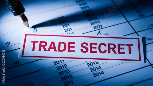 A close-up view of a confidential document marked with a red trade secret stamp