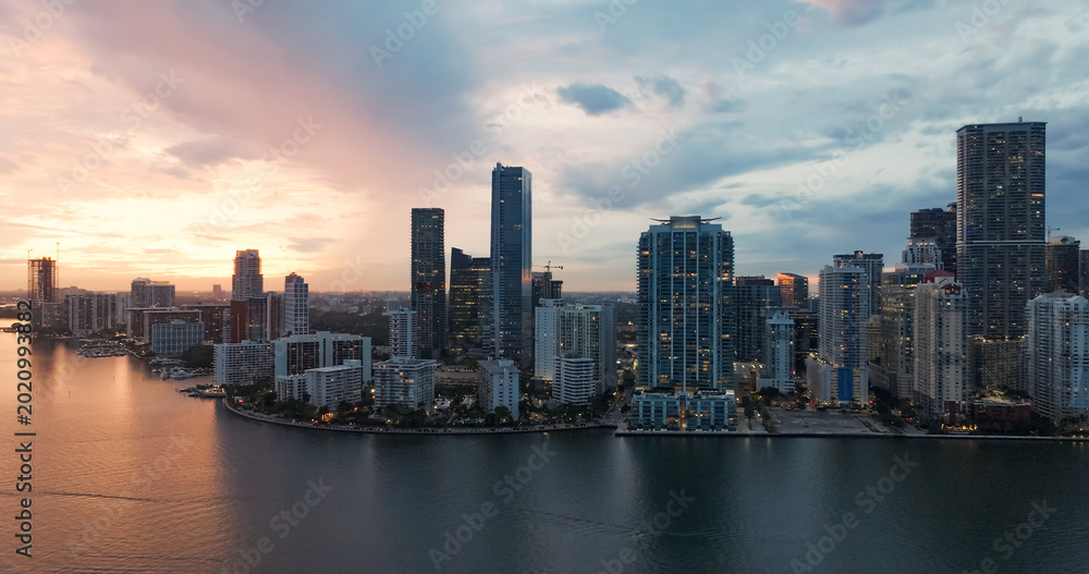 Fototapeta premium Miami downtown skyline illuminating biscayne bay at sunset