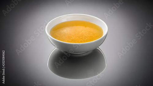 High contrast chicken essence soup reflection composition creates dramatic premium food photography aesthetic in studio setting